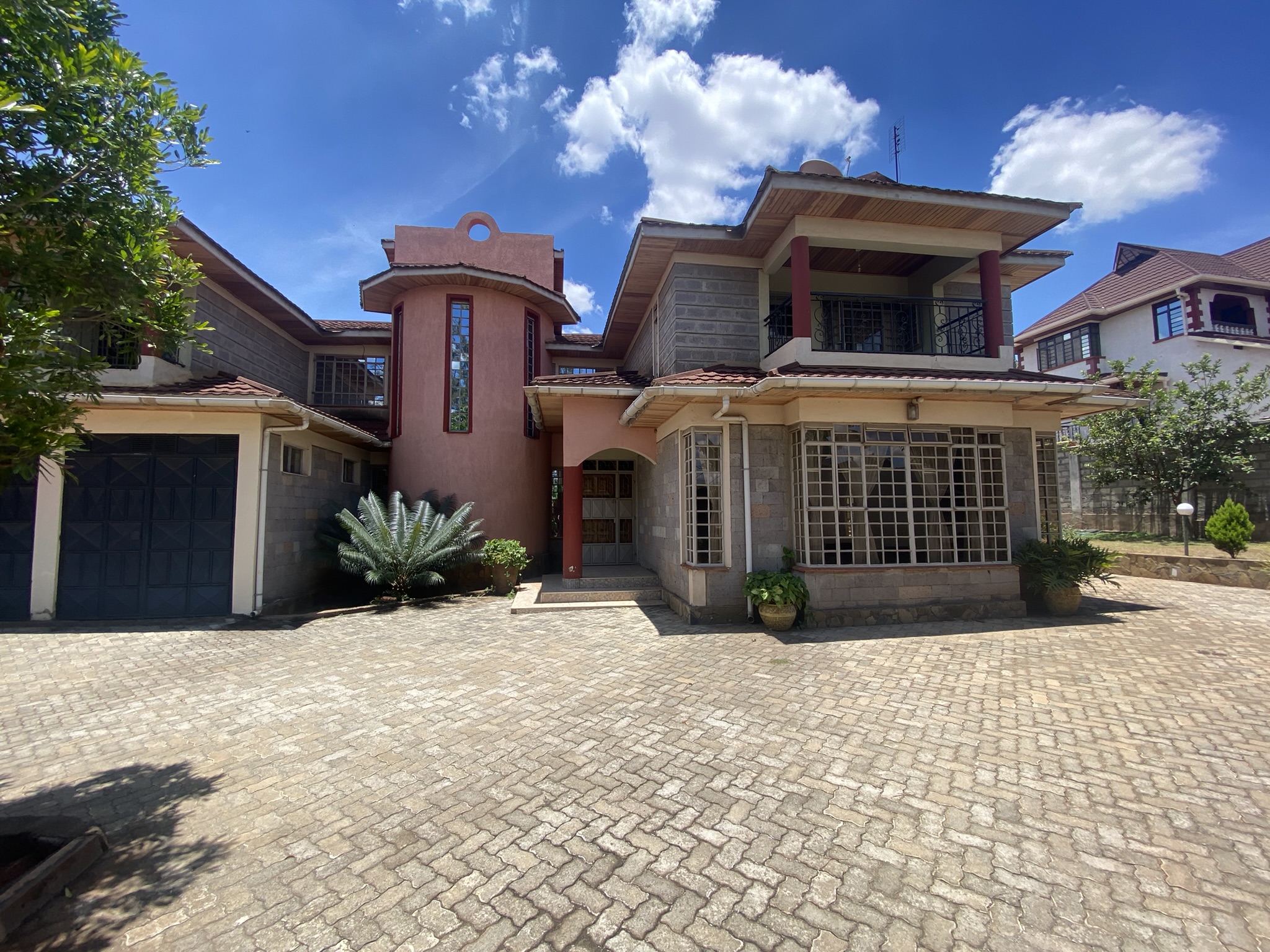 A  five bedroomed double storey residential house with a detached ablution block.